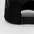 closeup of back of black meshback cap showing "ARCHERY COUNTRY" label