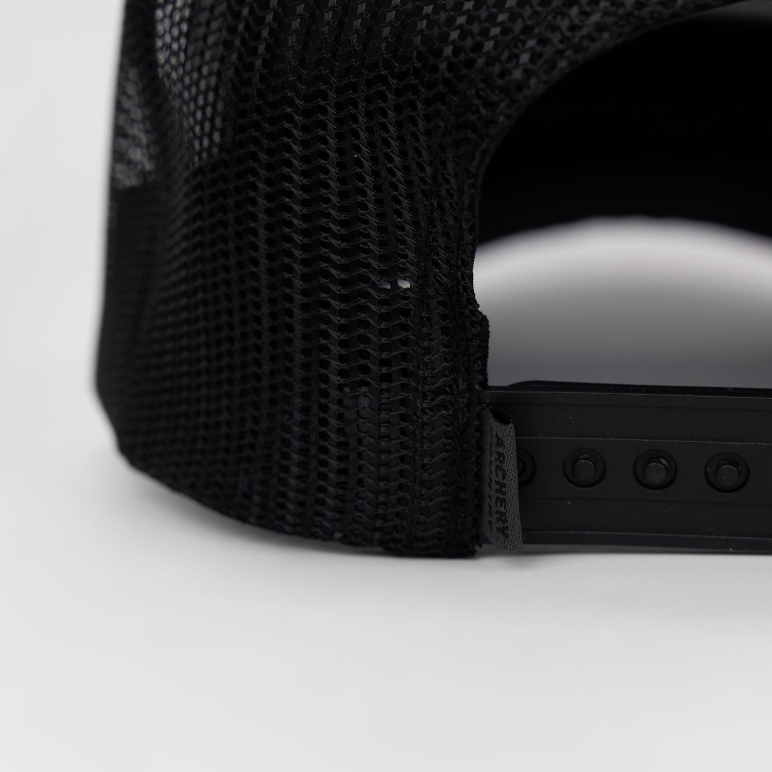 closeup of back of black meshback cap showing "ARCHERY COUNTRY" label