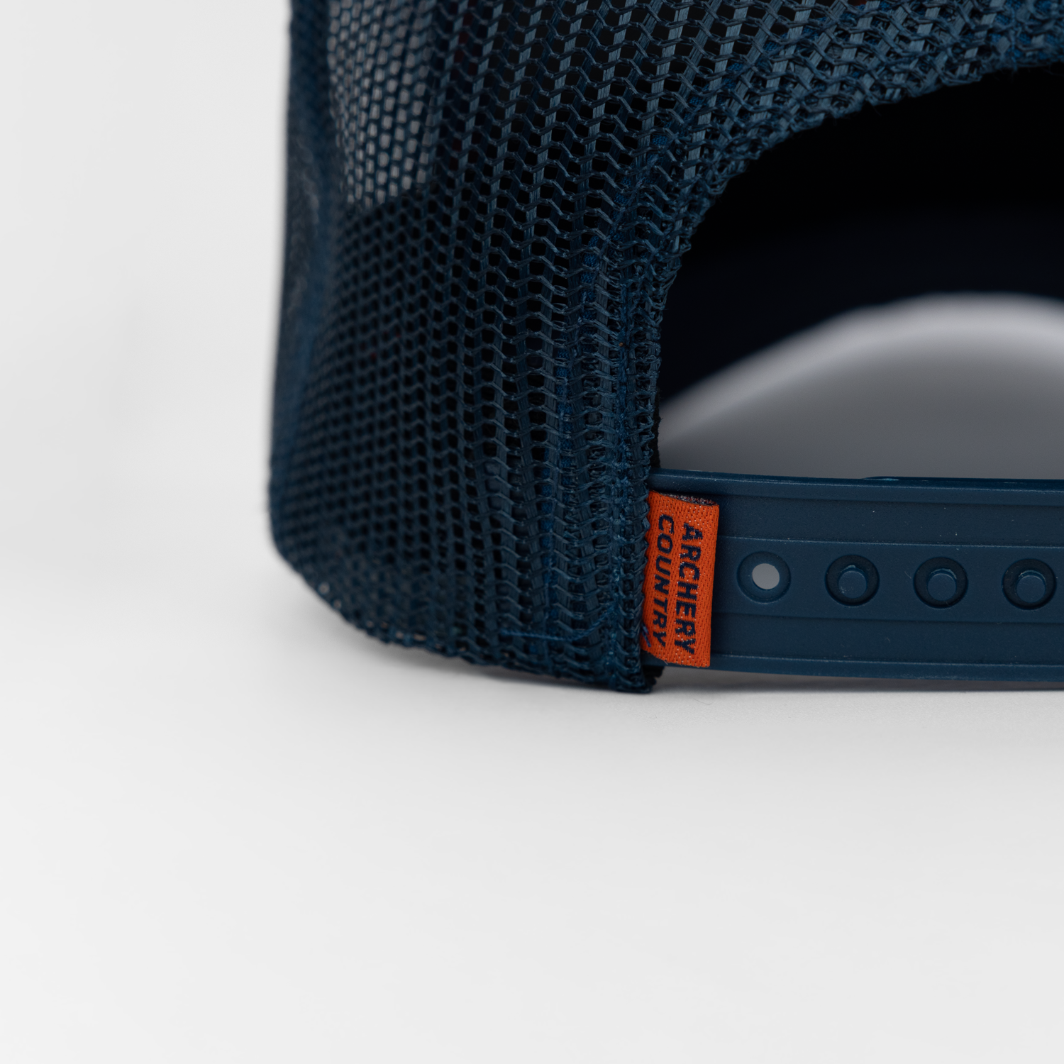 Closeup of back of navy meshback cap showing "ARCHERY COUNTRY" label