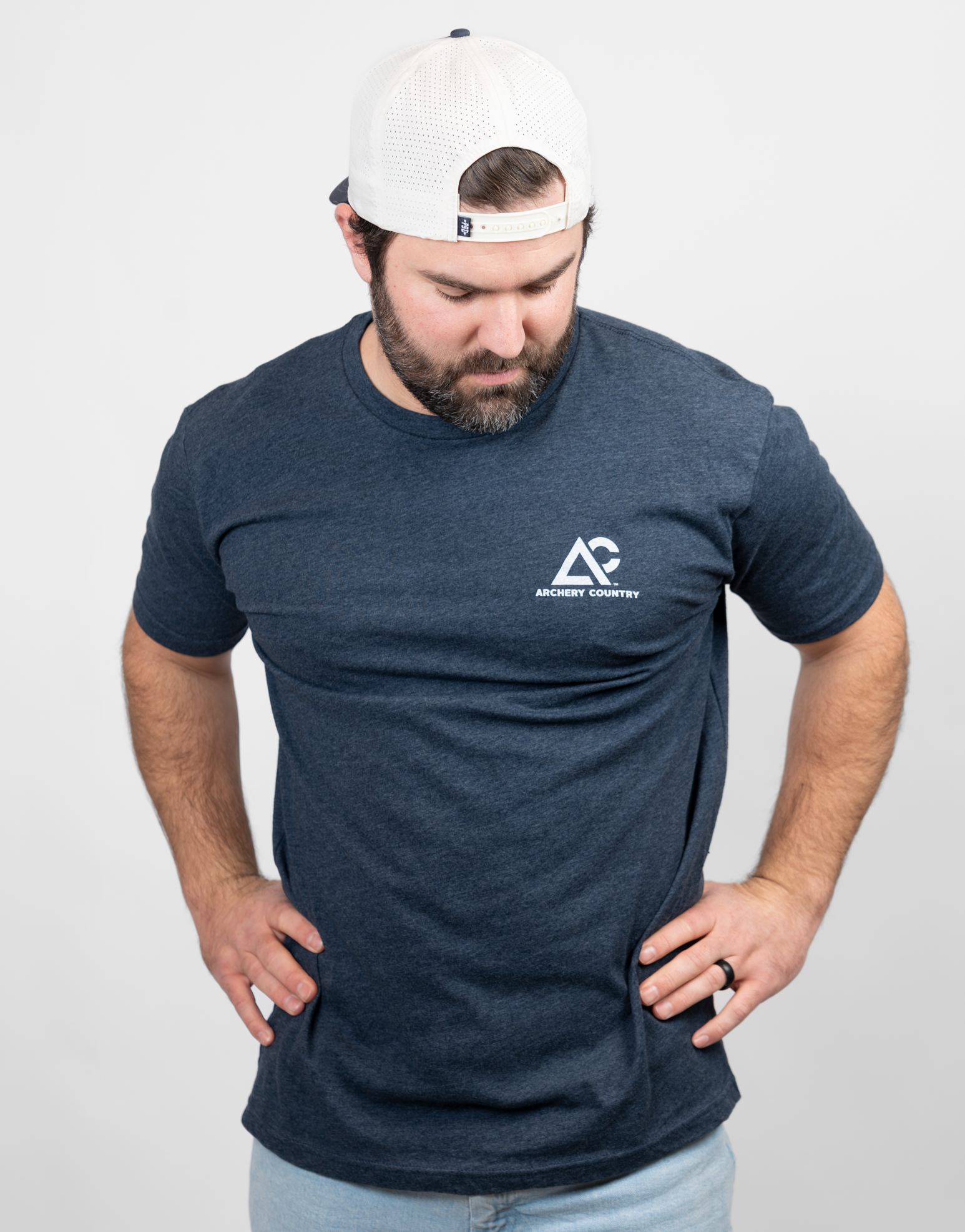 Man wearing heather navy tee with small Archery Country logo on left chest