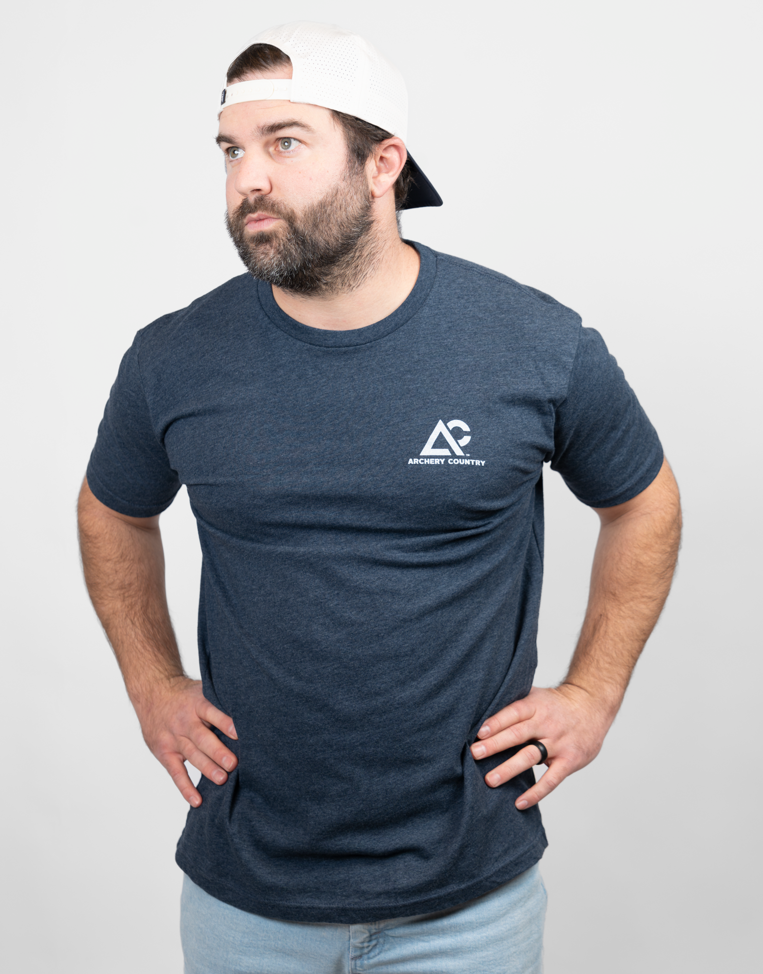 Man wearing heather navy tee with small Archery Country logo on left chest