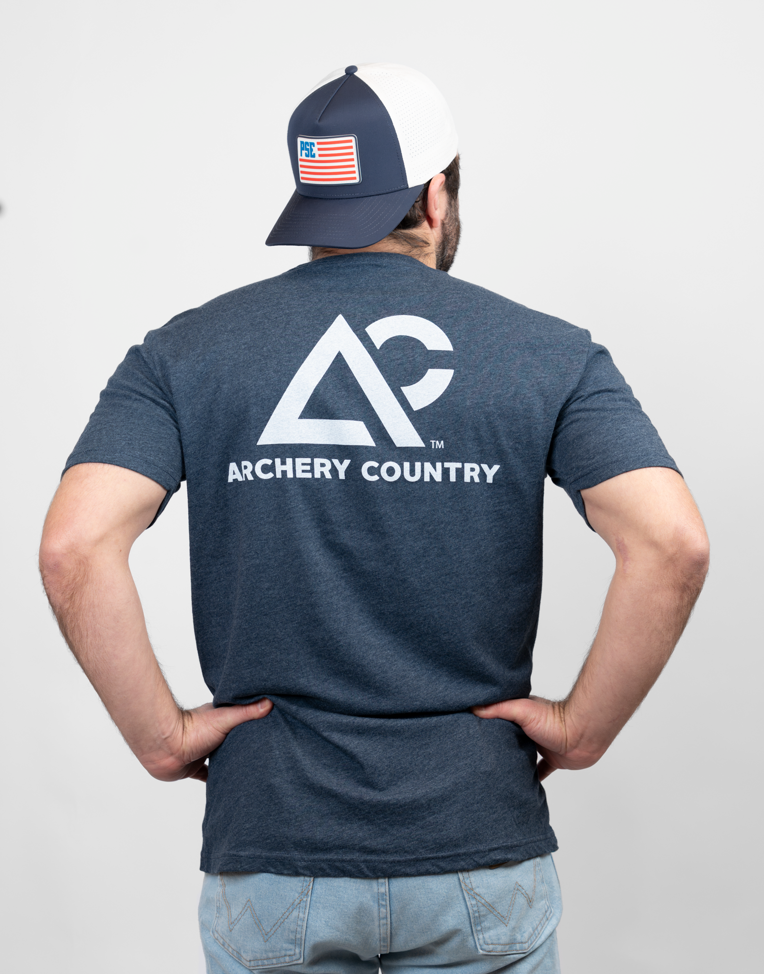 Rear view of man wearing heather navy tee with "Archery Country" logo on back