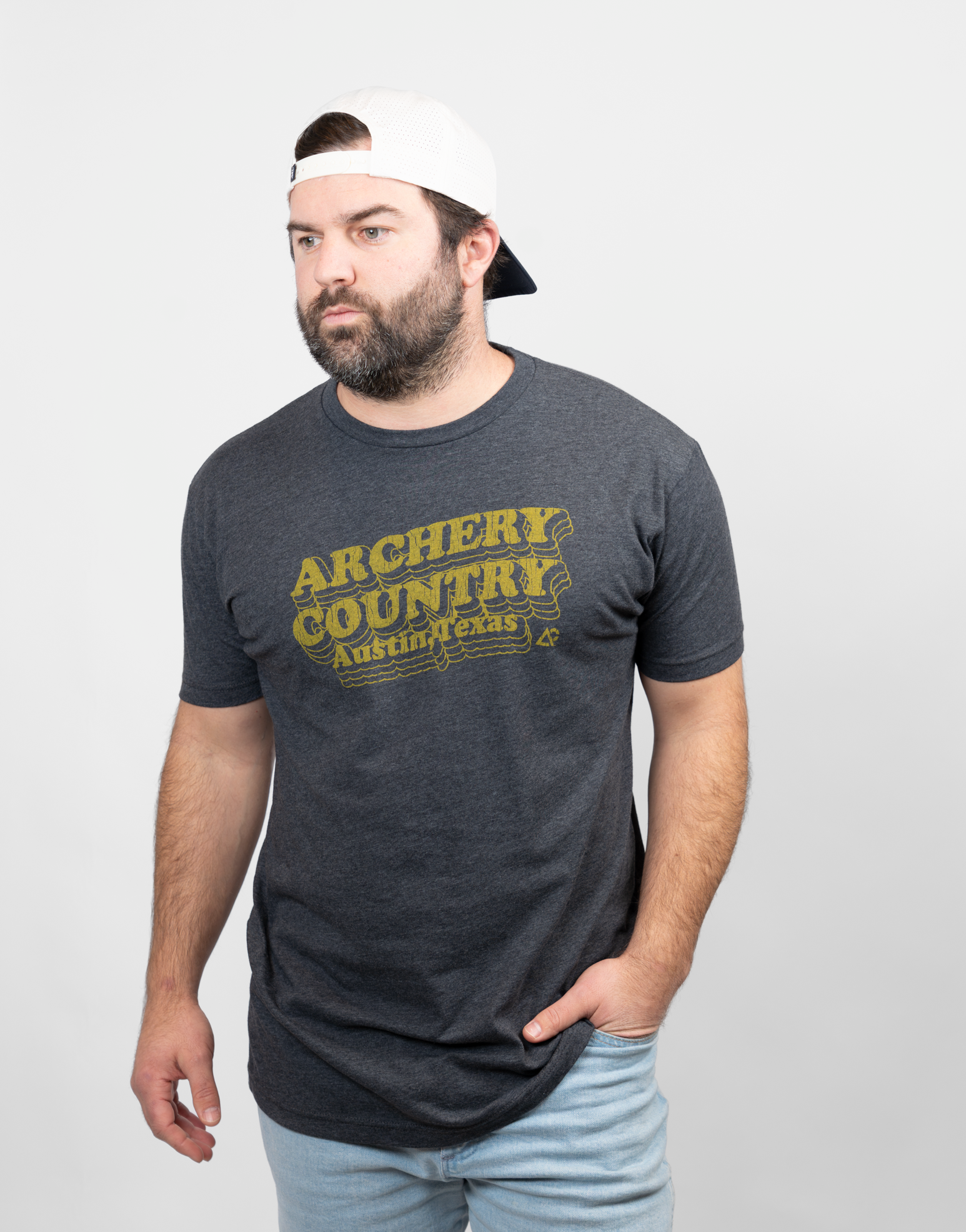 Man wearing charcoal tee with text "ARCHERY COUNTRY Austin, Texas"