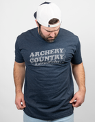 Man wearing heather navy tee with text "ARCHERY COUNTRY Austin, Texas"