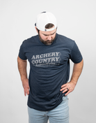 Man wearing heather navy tee with text "ARCHERY COUNTRY Austin, Texas"