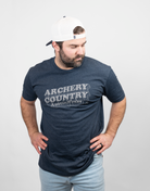 Man wearing heather navy tee with text "ARCHERY COUNTRY Austin, Texas"