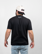 rear view of man wearing black tee with "ARCHERY COUNTRY" text on upper back