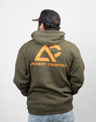 Person wearing a green hoodie with orange 'Archery Country' logo on the back 