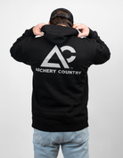 man wearing black hoodie with large Archery Country logo on back